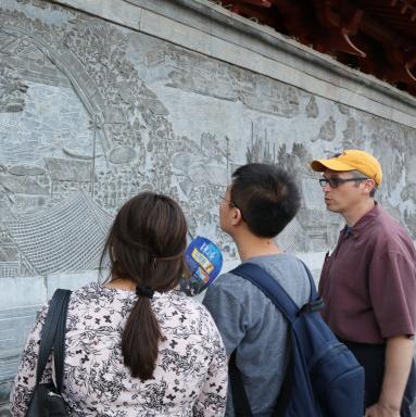 Professors and students study a relief panel in the Yellow river area of China during the Landsca...